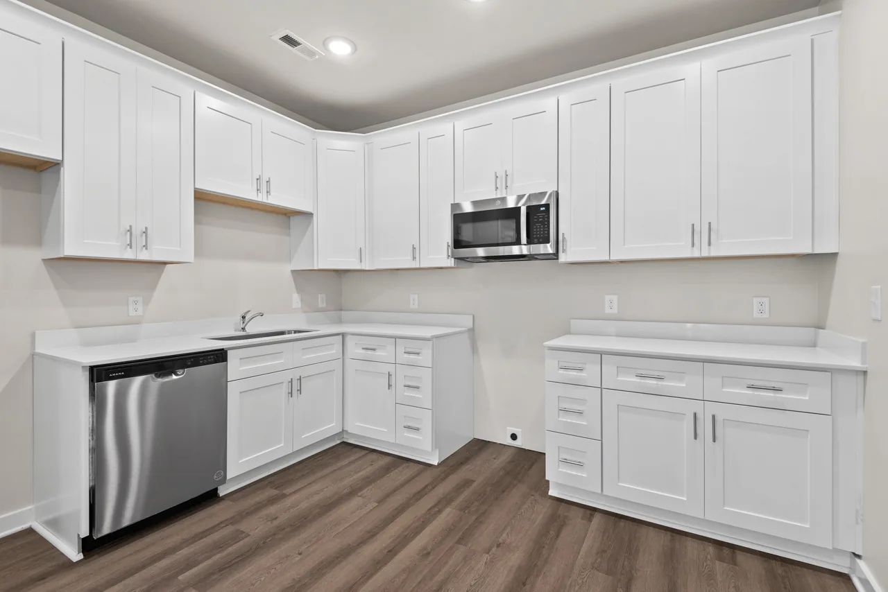 Bright kitchen with white cabinets, microwave, and dishwasher